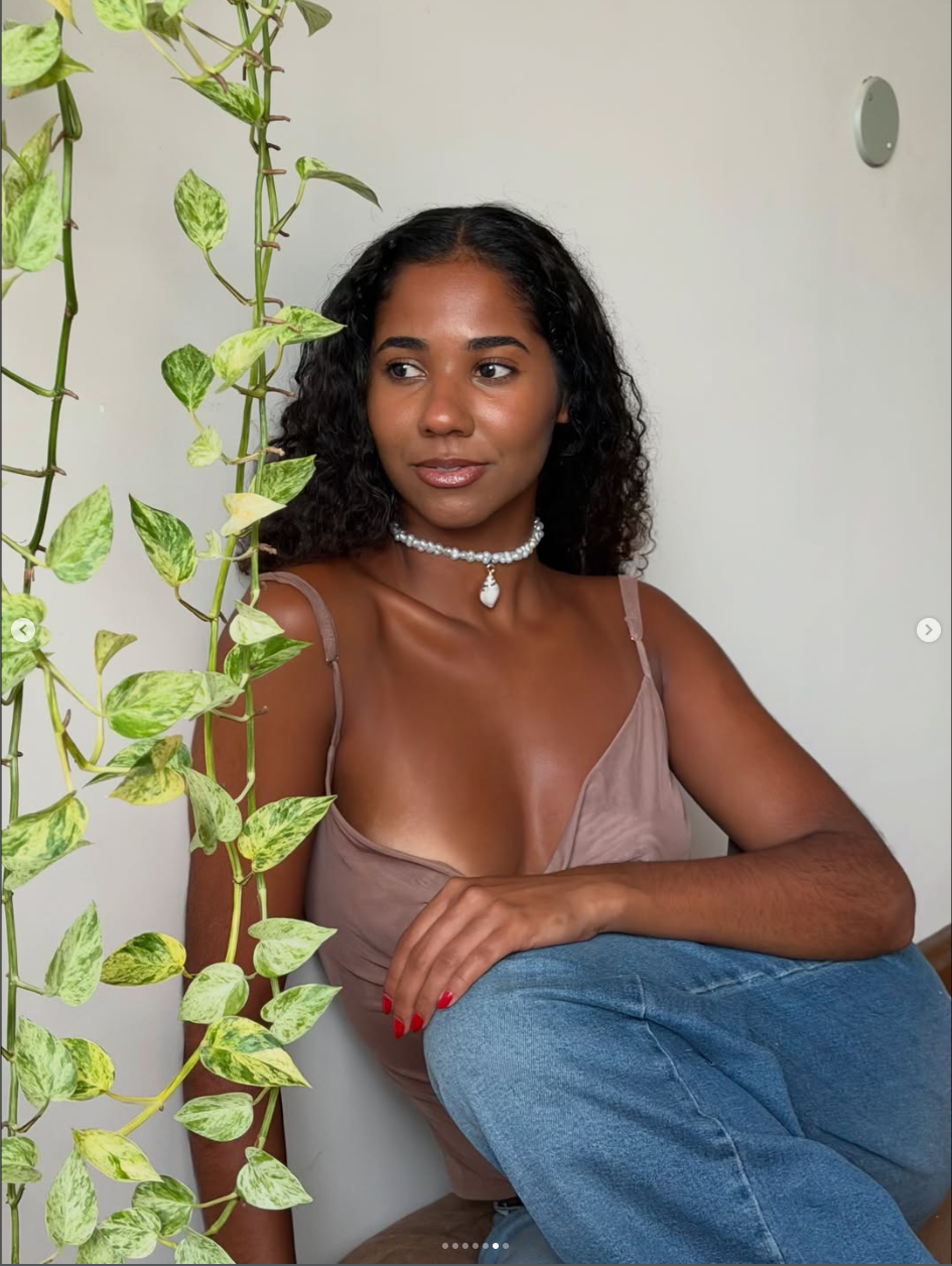 Retrato de mulher usando choker de pérolas almare em ambiente com planta